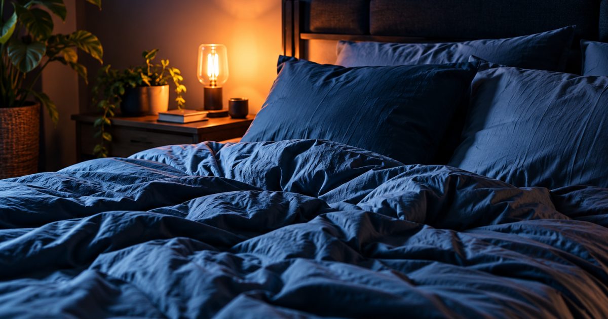 Chambre calme éclairée par une lampe de chevet.