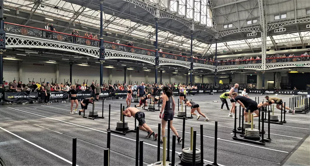 Athlètes participant à une course HYROX, alternant exercices et running