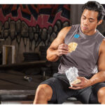 homme musclé mangeant une collation pour prise de masse musculaire